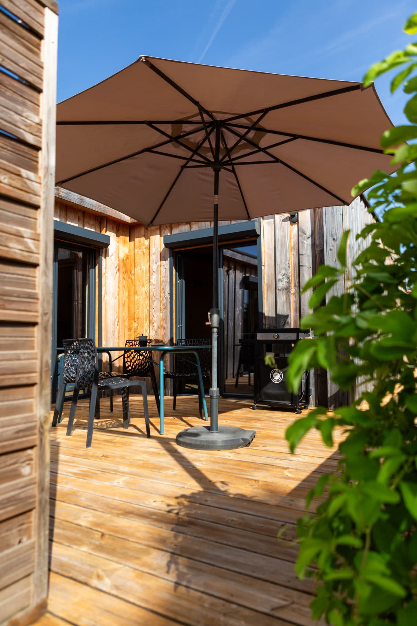 Terrasse privative avec parasol et plancha